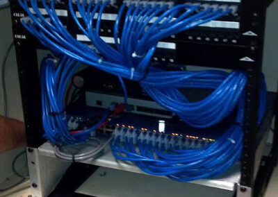 Installed under a cabinet, this custom-sized data rack holds a patch panel, network switch, and cable modem.