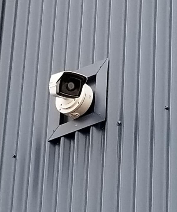 Bullet security camera installed on metal siding.